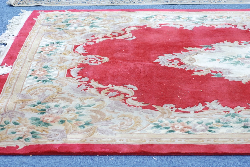 LARGE EMBOSSED WASHED CHINESE CARPET, of Aubusson design with fawn and floral oval centre
