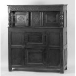 MID 17th CENTURY CARVED OAK COURT CUPBOARD, the carved canopy with turned supports, enclosing a pair