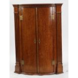 LATE 18th CENTURY OAK BOW FRONTED CORNER CUPBOARD, the dentil moulded cornice above a pair of