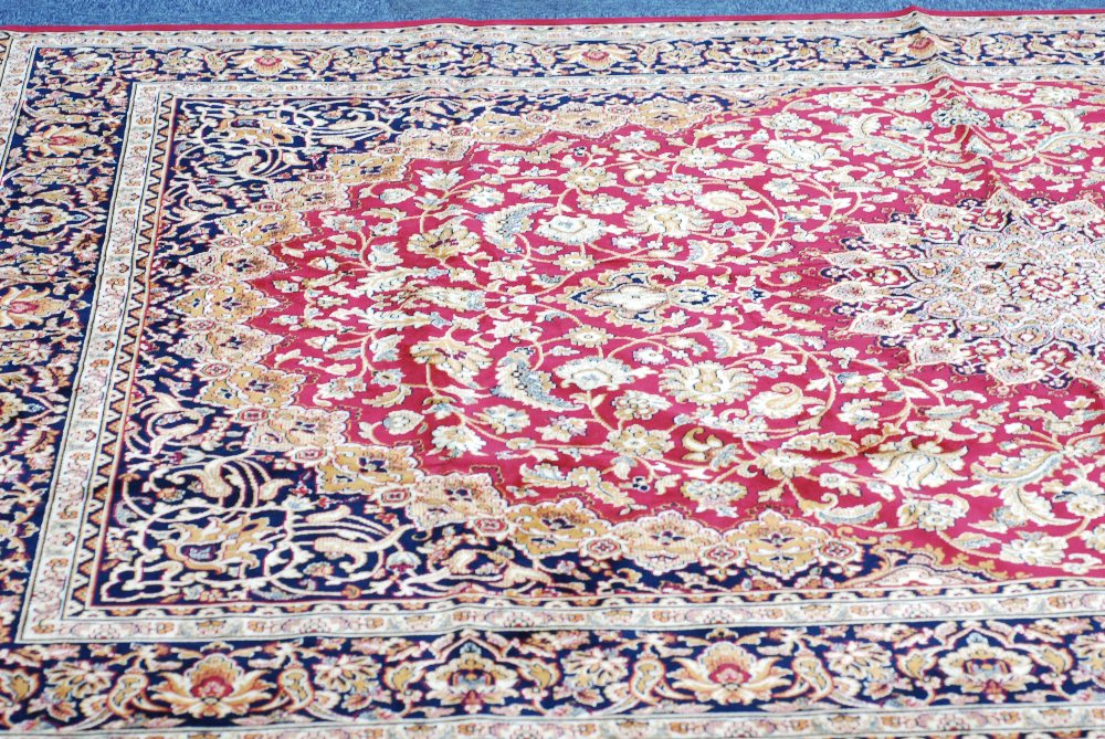 MODERN MACHINE MADE EASTERN CARPET ON RED GROUND, 79" x 107 ½"