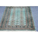 PAKISTAN 'BOKHARA' RUG, with two rows of guls, on a turquoise field, 5' x 3'