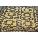 TURKOMAN RUG, gold and black with a tile pattern of six large square guls, on a patterned field,