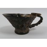 CHINESE CARVED COW HORN LIBATION CUP, of typical form, decorated with figures and foliage, 2 3/4" (