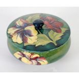 WALTER MOORCROFT HIBISCUS PATTERN TUBE LINED POWDER BOWL AND COVER, typical form, decorated in tones