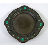 EARLY TWENTIETH CENTURY EMBOSSED PEWTER SHALLOW DISH, the rim decorated in turquoise and green