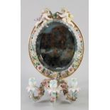 CONTINENTAL FLORAL ENCRUSTED PORCELAIN GIRANDOLE with oval bevelled edge mirror in porcelain frame