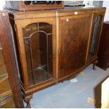 A FIGURED WALNUT DISPLAY CABINET WITH CENTRE PANEL DOOR FLANKED BY GLAZED DOORS, ON CARVED STUMP