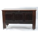 LATE SEVENTEENTH CENTURY CARVED OAK COFFER, the later rounded oblong top above a triple panelled