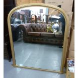 A VICTORIAN TALL ARCH TOPPED OVER MANTEL MIRROR, IN CAVETTO MOULDED GILT FRAME