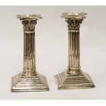 PAIR OF EDWARDIAN SILVER CORINTHIAN COLUMN TABLE CANDLESTICKS, with removable drip trays, on