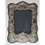 EASEL PHOTOGRAPH FRAME, the silver front repousse with angels heads and foliate scrolls, 8 1/2"