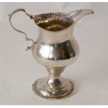 GEORGE III SILVER CREAM JUG, with plain pyriform body with punch beaded border, acanthus capped