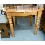 A MODERN PINE OVAL DINING TABLE EXTENDING WITH A FOLDING LEAF STORED BENEATH, ON FOUR TURNED