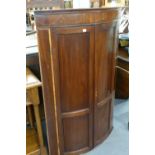 A NINETEENTH CENTURY PANELLED MAHOGANY BOW FRONT CORNER CUPBOARD