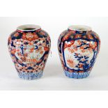 PAIR OF JAPANESE IMARI FLUTED BALUSTER VASES, decorated with reserves with garden scenes, 8 ½" (21.