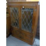 A DARK OAK DISPLAY CABINET WITH LEADED AND GLAZED DOORS (136cm high x 86cm wide )