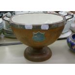 A LARGE POTTERY LINE OAK PEDESTAL FRUIT BOWL WITH ELECTROPLATE RIM AND HANDLE AND A BREAD BOARD ON