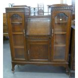 A CARVED OAK SIDE BY SIDE BUREAU BOOKCASE, IN PERIOD STYLE, RAISED ON LEGS