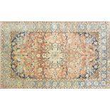 FINELY KNOTTED KIRMAN RUG, with star shaped centre medallion with pendants on a pink field scattered