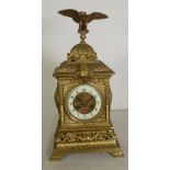 LATE NINETEENTH CENTURY EMBOSSED BRASS MANTEL CLOCK, the 3 1/2" Arabic dial with gilt scroll