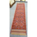 MESHWANI HAND KNOTTED WOOL RUNNER, WORKED IN RED AND BLUE WITH TWO ROWS OF SIX DIAMOND SHAPED