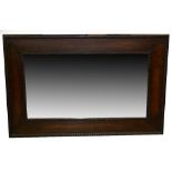 AN OBLONG BEVELLED EDGE WALL MIRROR,, THE OAK FRAME WITH BEADED AND GADROON BORDERS