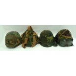 FOUR VARIOUS AMERICAN AND NATO ISSUE POST-WAR HELMETS each with covering of camouflage fabric,