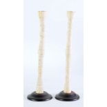 PAIR OF JAPANESE LATE MEIJI PERIOD CARVED BONE CANDLESTICKS, each of sectional, cylindrical form,