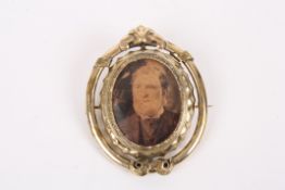 A Victorian pinchbeck reversible portrait broochthe scrolled frame set with reversible oval panel.,