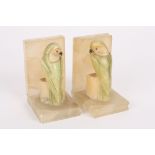 A pair of 1930s carved onyx and hardstone bookends
modelled as parakeets seated on blocks, with