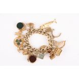 A large curb link 9ct gold charm bracelet with some 15ct charms
the charms comprising a horn