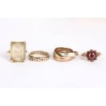 A group of four gold rings
comprising: a 9ct gold garnet cluster ring, a 9ct gold eternity ring, a