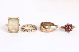 A group of four gold ringscomprising: a 9ct gold garnet cluster ring, a 9ct gold eternity ring, a