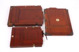 A collection of three early 20th century mahogany camera plateseach with inset numbers, the