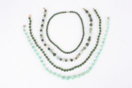 Three 20th Century Chinese green hardstone bead necklacestogether with another graduated