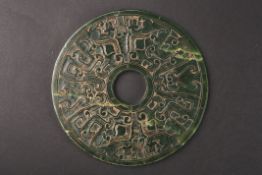 A large 20th century spinach green jade roundelcarved on both sides with Chinese symbols in low