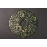 A large 20th century spinach green jade roundel
carved on both sides with Chinese symbols in low