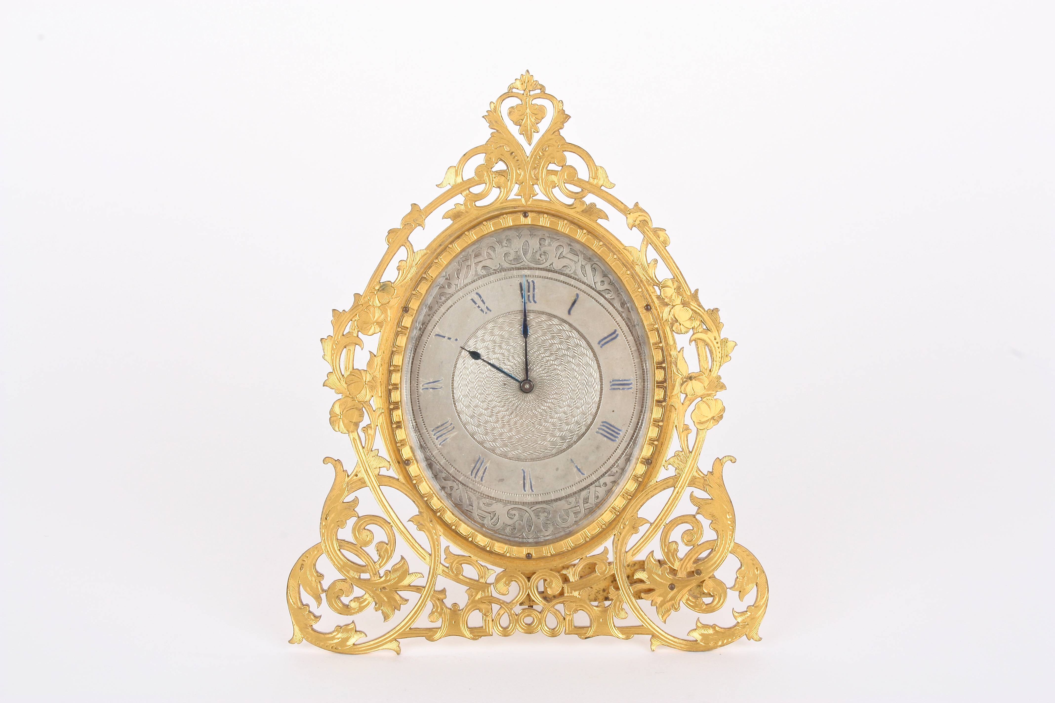 A Victorian gilt metal easel clock by London & Ryder
the engraved oval silvered dial with blued