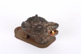 A 19th century painted spelter boars head paper clipmounted on a shield shaped metal bracket,
