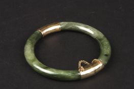 A Chinese dark green hardstone and yellow coloured metal banglewith safety chain, Condition: