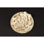 A large 20th century Chinese carved pale jade roundel 
carved in high relief with three water