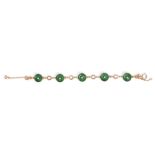 A gold, jade and diamond bracelet
set with five apple green jade roundels, each with carved