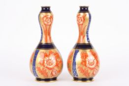 A pair of Macintyre double gourd vasesdecorated with red flowers on blue and gilt grounds, the base