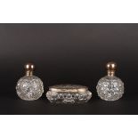 A pair of silver mounted cut glass dressing table bottles
together with a matched silver topped oval