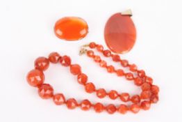 A graduated carnelian bead necklacethe beads faceted and with gold coloured metal fastening,