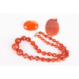 A graduated carnelian bead necklace
the beads faceted and with gold coloured metal fastening,