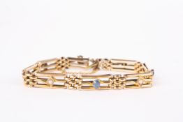 A 15ct gold three bar gate bracelet set with four oval sapphires and four seed pearl studs., 14.7