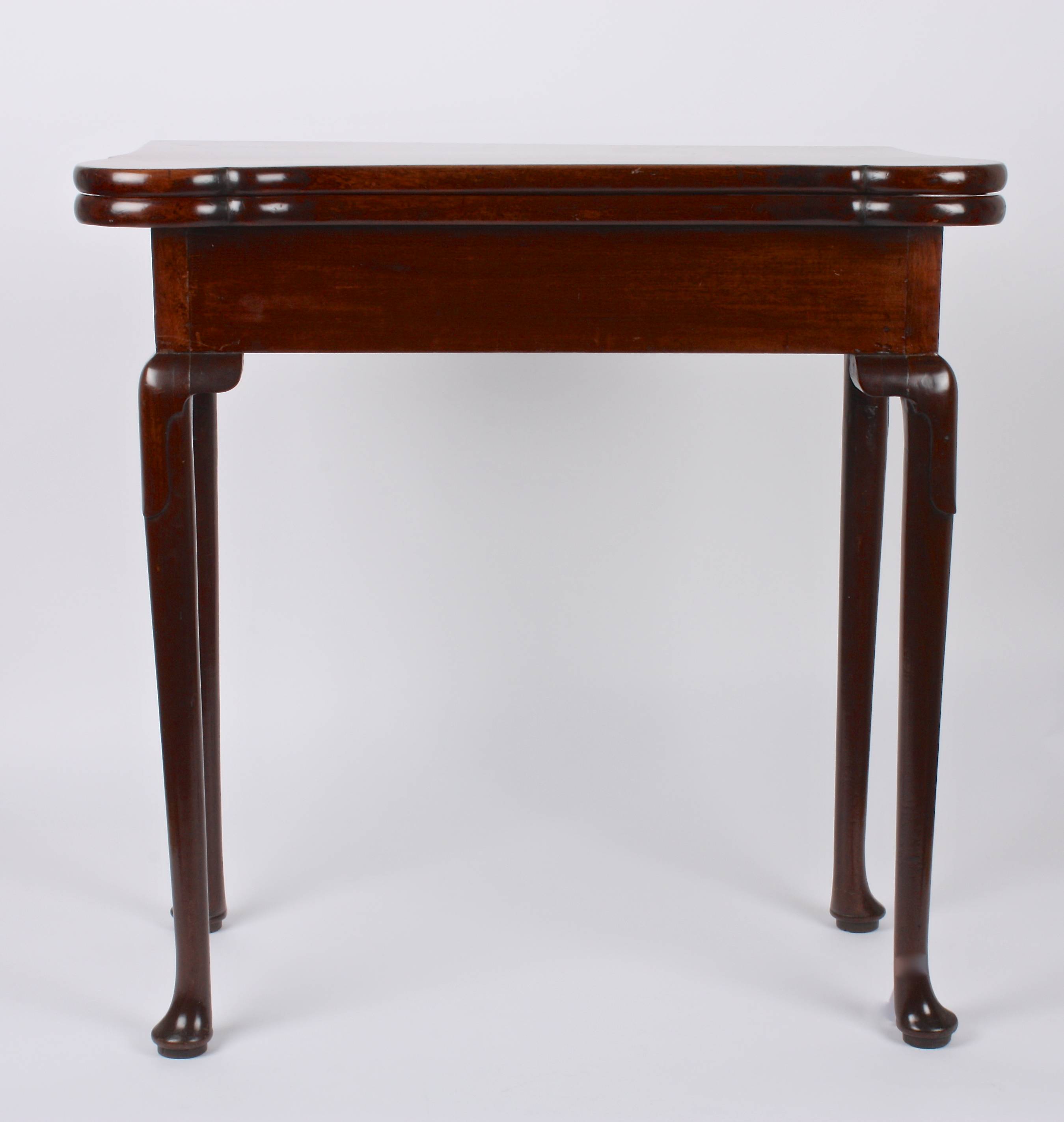 A George II mahogany foldover card table
the shaped top opening to reveal circular carved trays