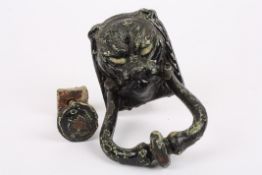 A Victorian cast iron panthers head door knockerwith weather black painted finish, together with