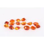 A set of amber coloured beads
abstract shaped with inclusions, together with a few spare beads,